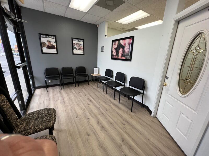 A dental clinic lobby with six black chairs