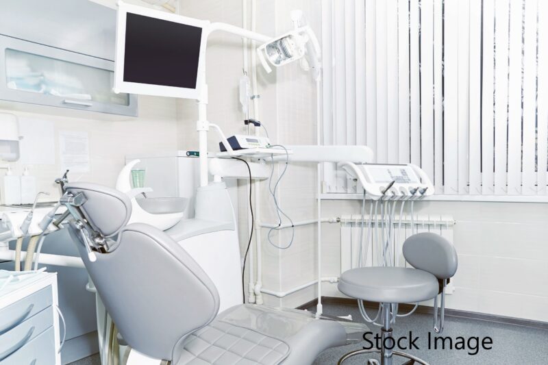 A dentist 's office with chairs and equipment.